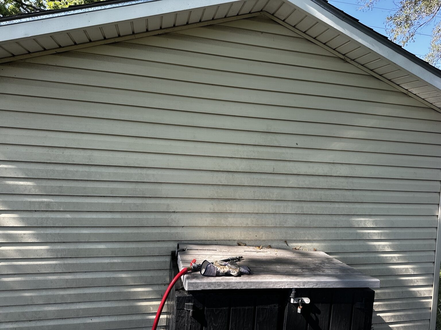 Discolored vinyl garage siding before house washing in El Dorado