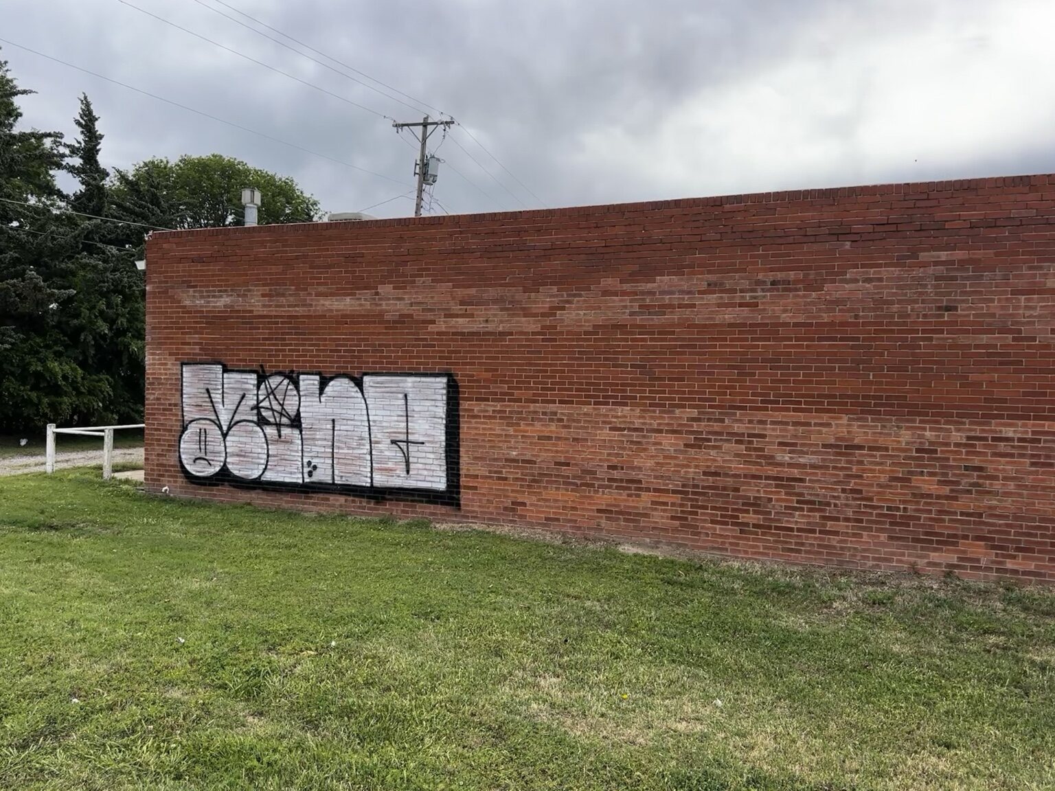 Tagged brick wall before graffiti removal in Wichita, Kansas